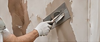 Skim coat being applied to a wall with a steel trowel