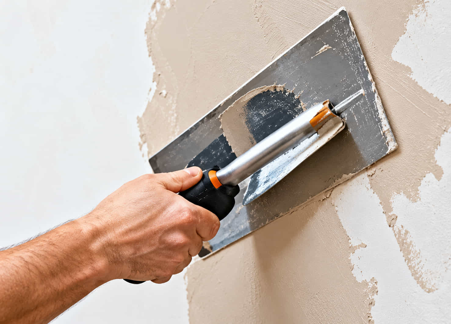 Skim coat being applied to a wall with a steel trowel